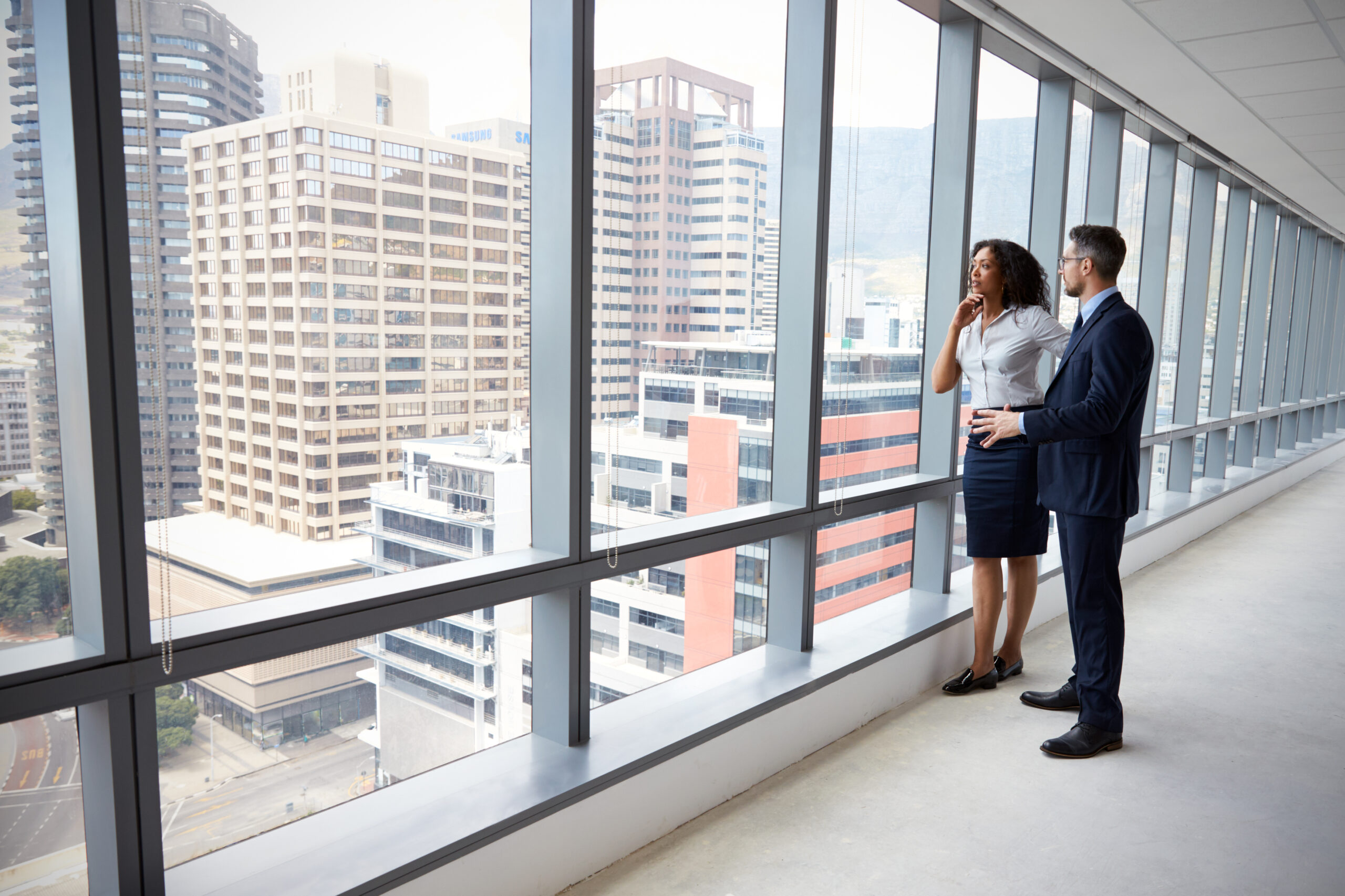 Portrait Of New Business Owners By Empty Office Window